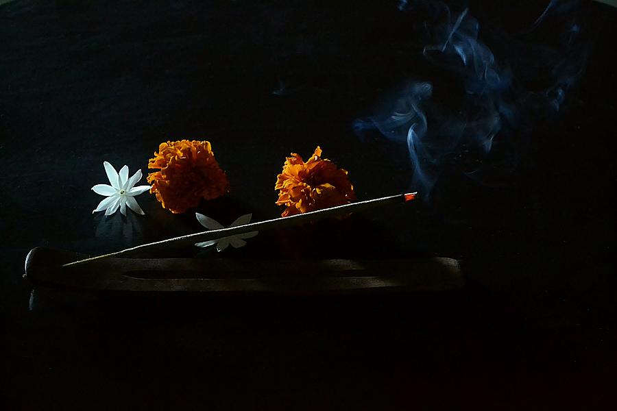 Burning incense sticks on a wooden incense holder and flowers Photograph by Veena Nair