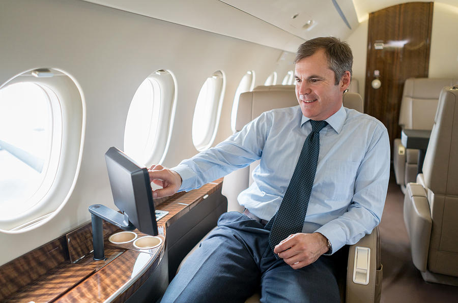 Business man traveling in a private jet Photograph by Andresr
