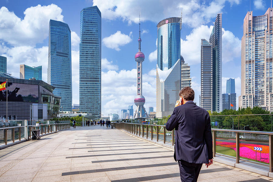 Business man walking and use smartphone in shanghai city Photograph by Anek Suwannaphoom