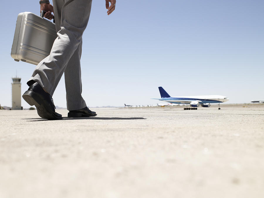Business Man Walking Toward Airplane Photograph by Ryan McVay