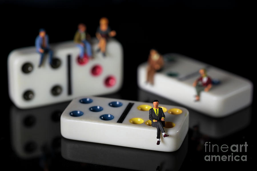 Business men and women on white dominoes isolated black background miniature people macro Photograph by Pablo Avanzini