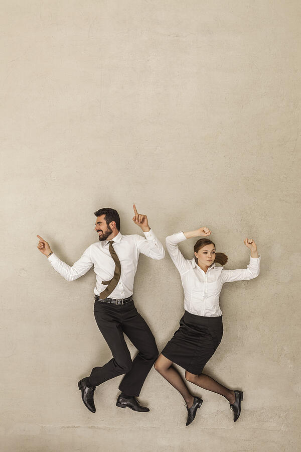 Business people dancing against beige background Photograph by Westend61