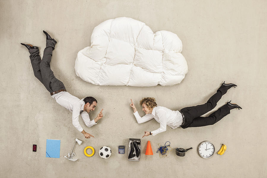 Business people flying between cloud shape pillow and variety of items Photograph by Westend61