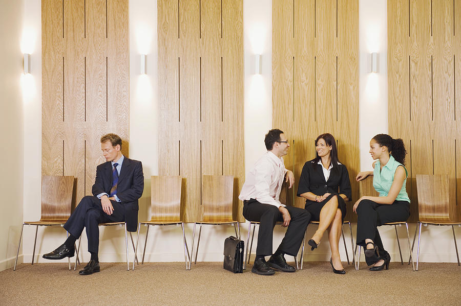 Business people ignoring businessman in waiting area Photograph by Jacobs Stock Photography Ltd