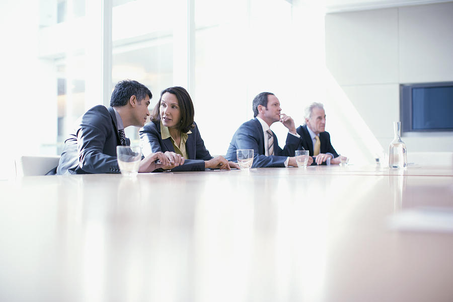 Business people sitting in conference room talking Photograph by Martin Barraud
