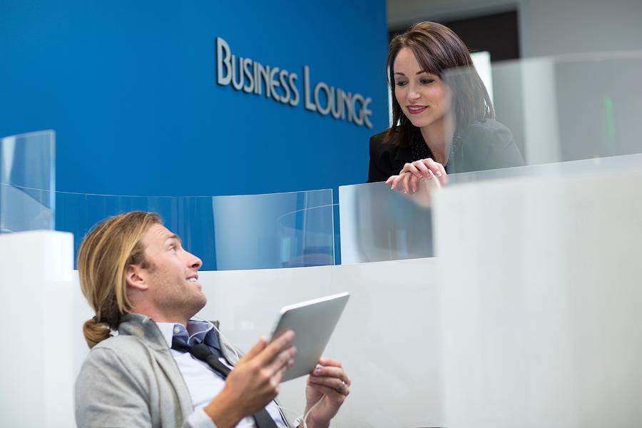 Business people talking in lounge Photograph by Image Source/InStock