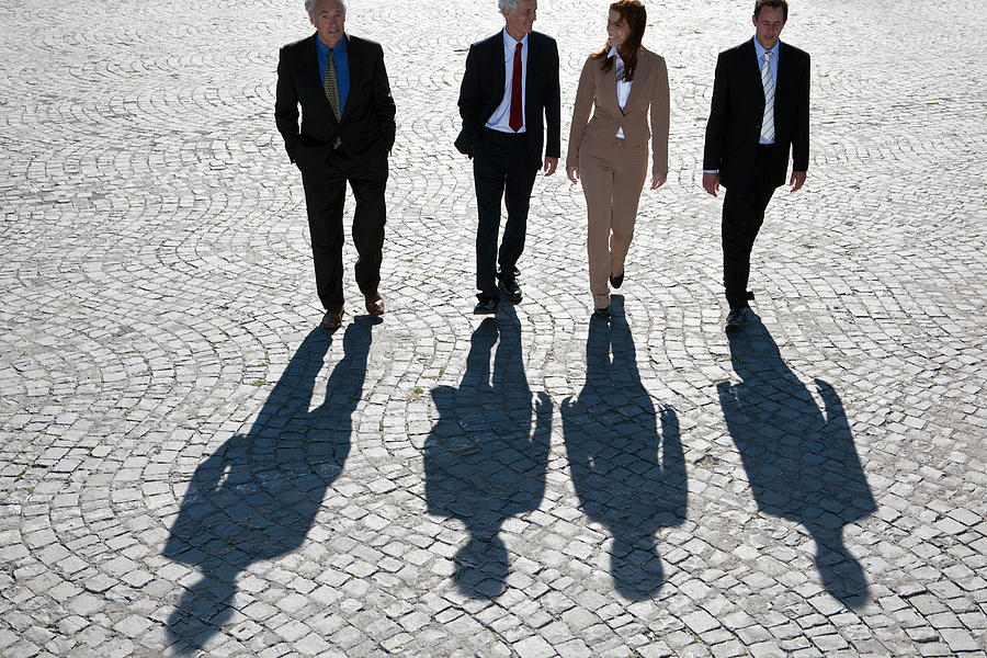 Business people walking on cobbled road Photograph by Chev Wilkinson