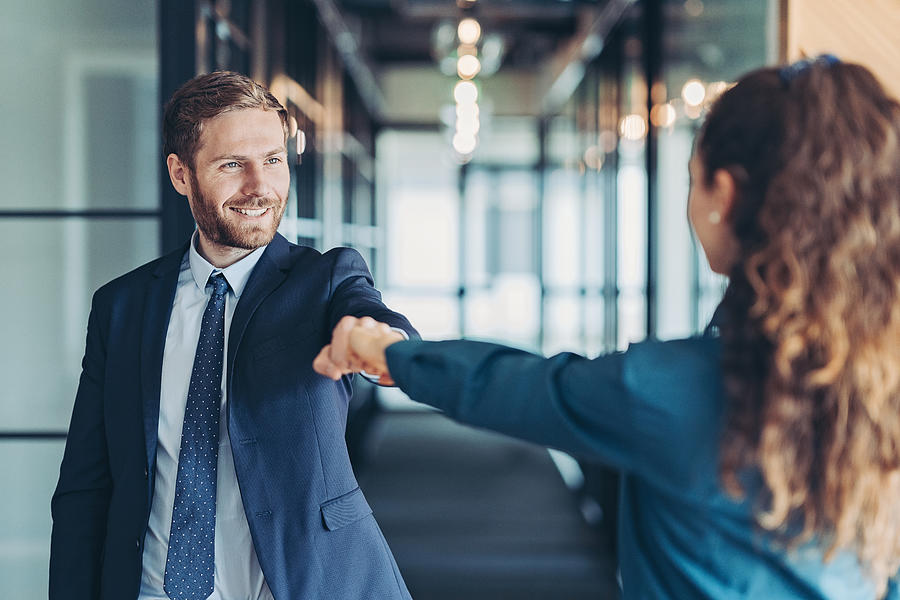 Business persons greeting with a fist bump Photograph by Pixelfit