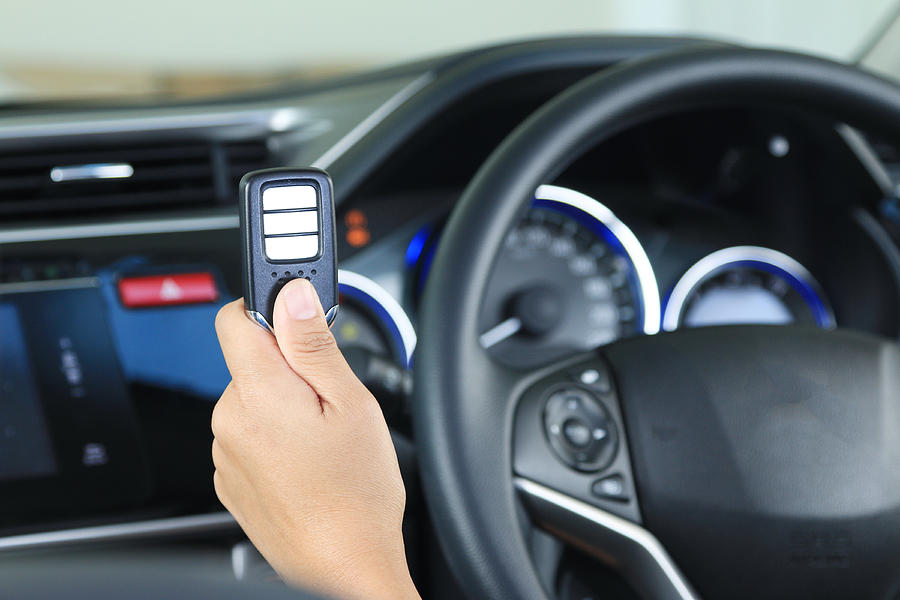 Business woman show remote key in modern vehicle car. Photograph by Ko_orn