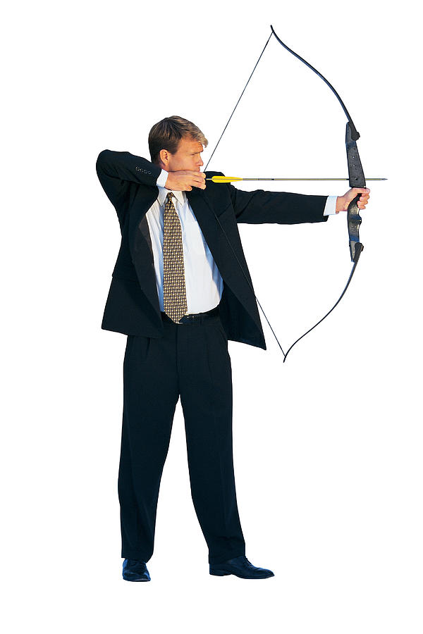 Businessman aiming bow and arrow Photograph by Comstock