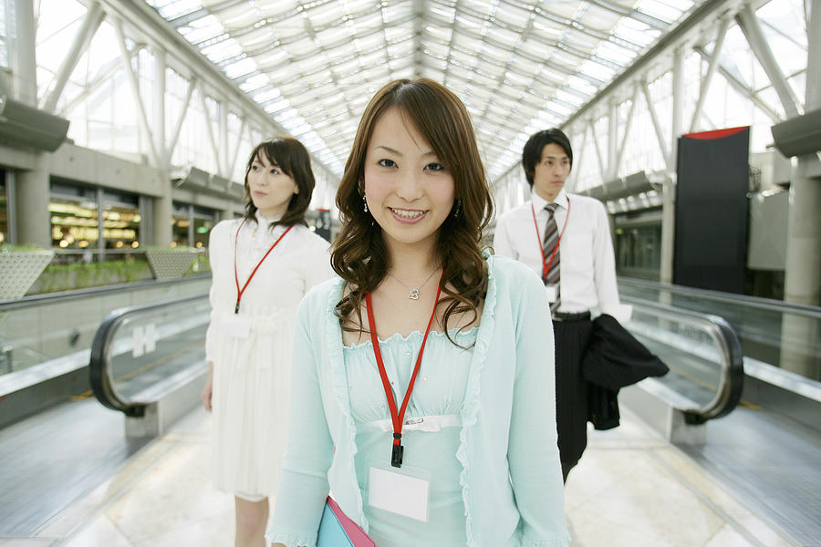 Businessman and two women walking, close-up Photograph by Tokyo Feminine Styling