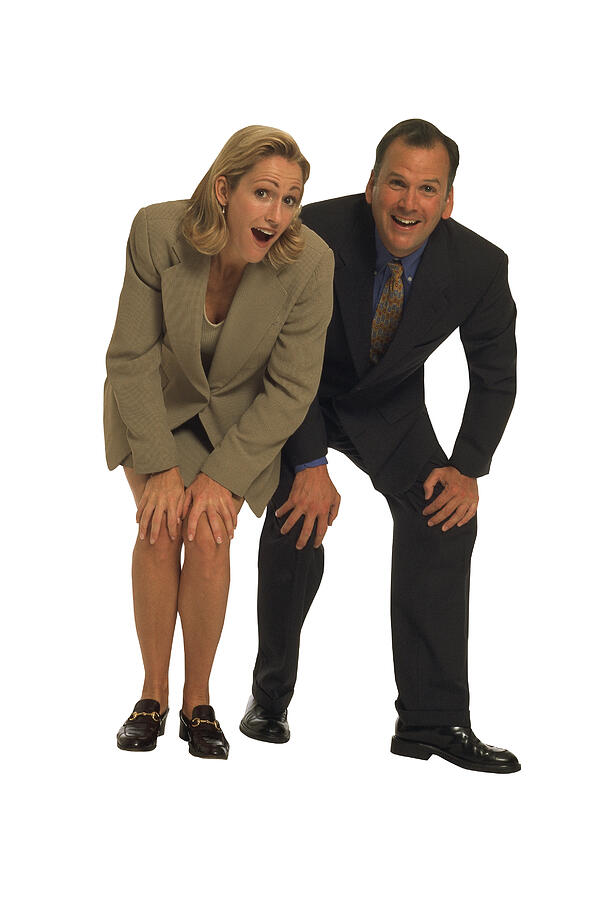Businessman and woman leaning forward with hands on knees Photograph by Comstock