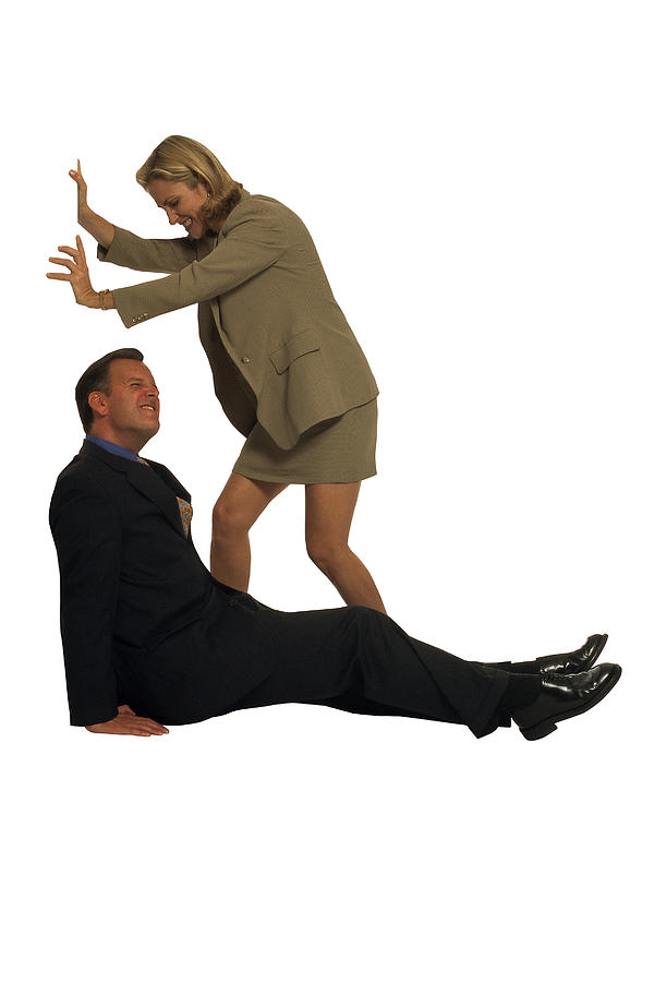 Businessman and woman pushing against unseen object Photograph by Comstock