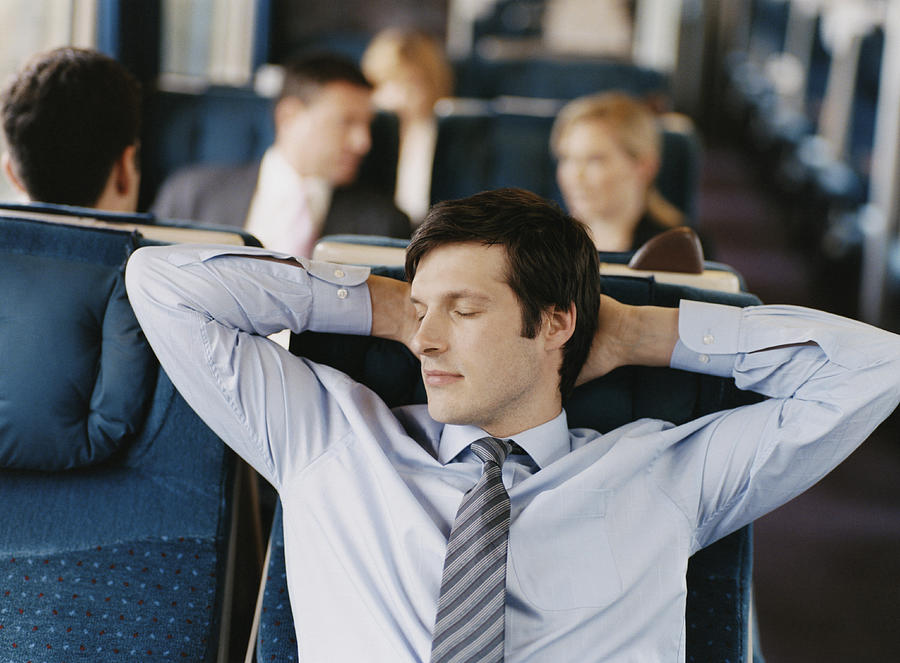 Businessman Asleep in His Seat on a Passenger Train Photograph by Digital Vision.