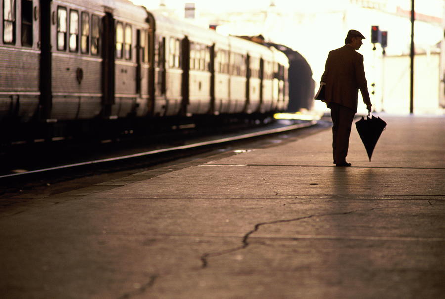 Businessman Awaits His Train Photograph by Geoffrey Clifford