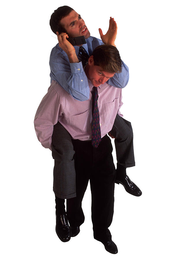 Businessman giving piggyback ride to businessman Photograph by Jupiterimages