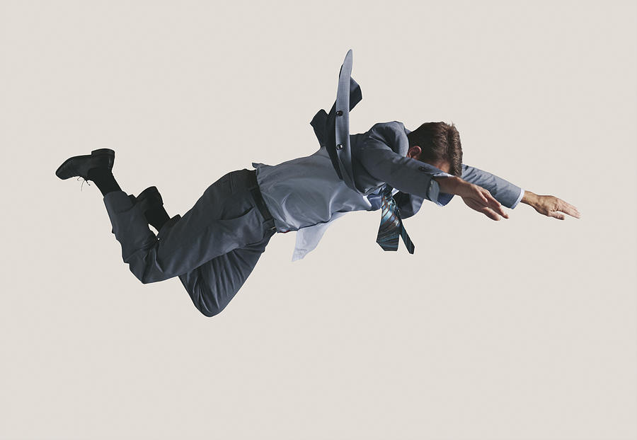 Businessman hanging in the air, wearing grey suit Photograph by Klaus Vedfelt