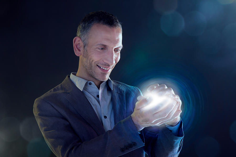 Businessman holding a ball of light Photograph by Image Source