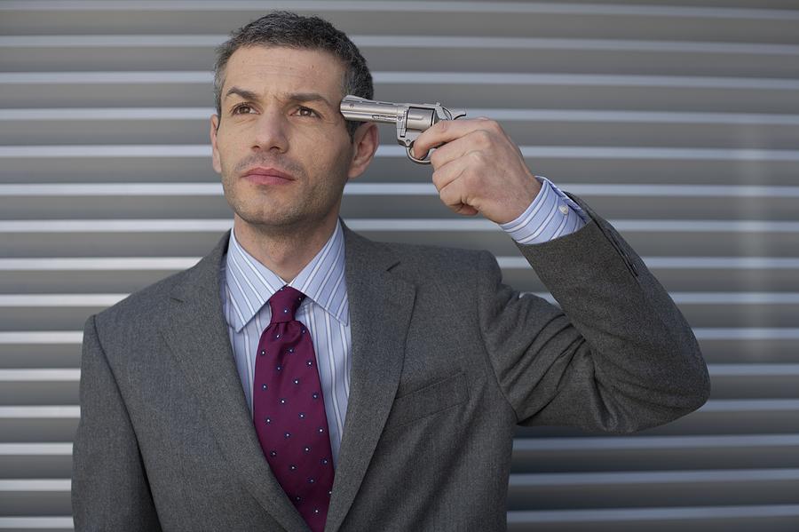 Businessman holding a gun to head Photograph by Stock4b-rf