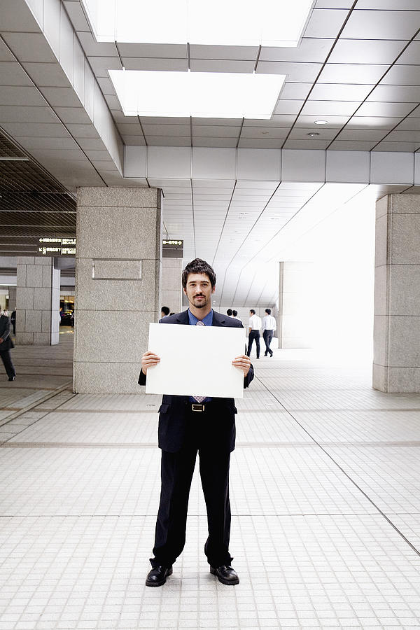 Businessman holding blank sign Photograph by Eric Chuang