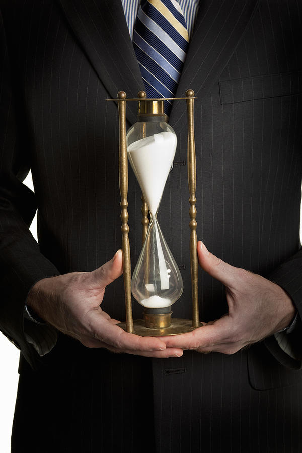 Businessman holding hourglass Photograph by Gary S Chapman