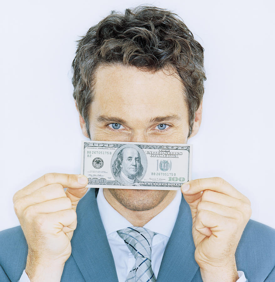 Businessman holding one hundred dollar banknote, portrait, close-up Photograph by Pando Hall