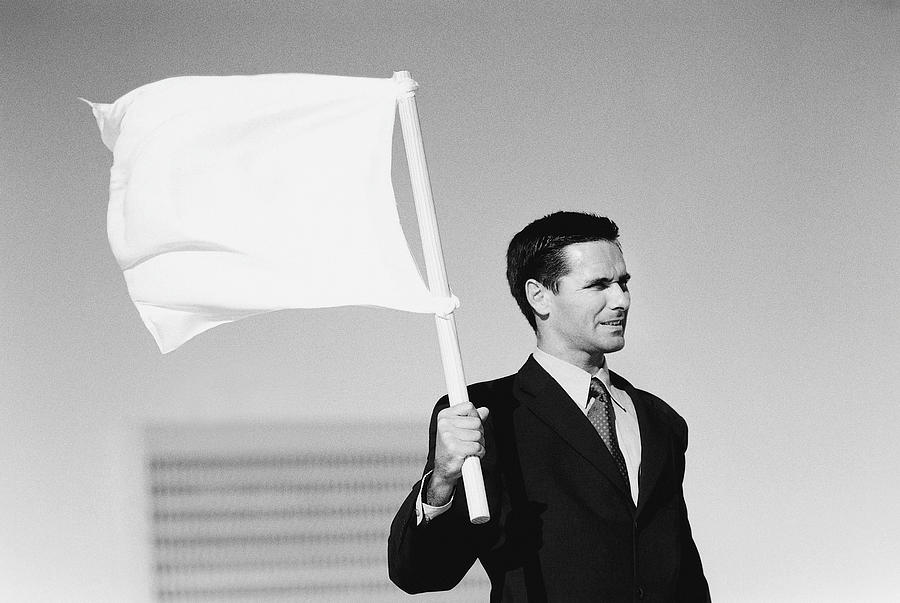 Businessman holding white flag Photograph by Digital Vision.