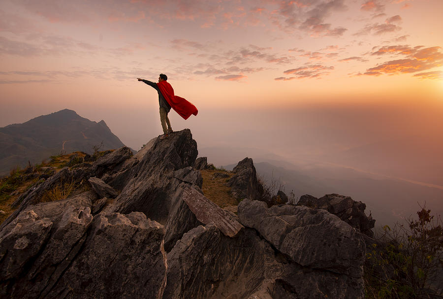 Businessman in a suit and cape hero on top of a mountain,Business Success concept. Photograph by seksan Mongkhonkhamsao