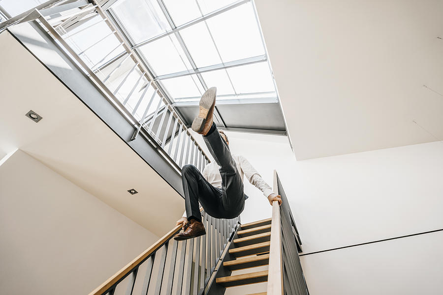 Businessman jumping down stairs Photograph by Westend61