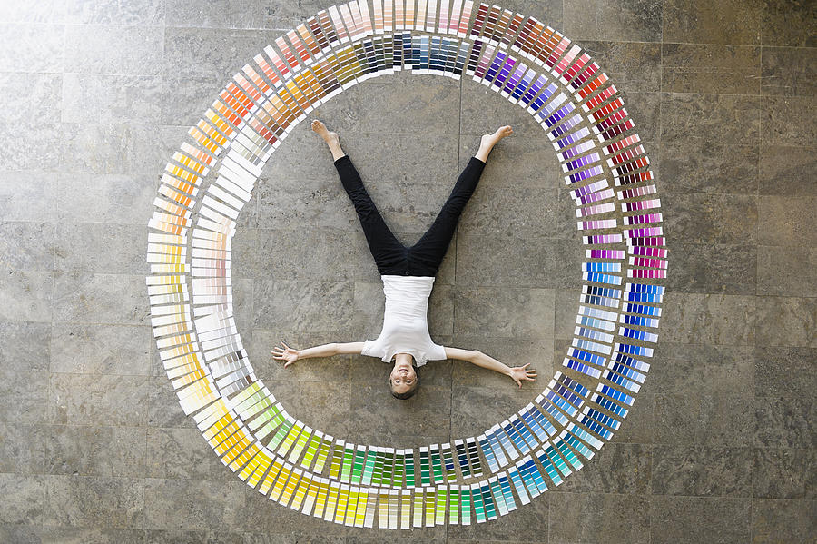 Businessman laying in paint swatches Photograph by Suedhang
