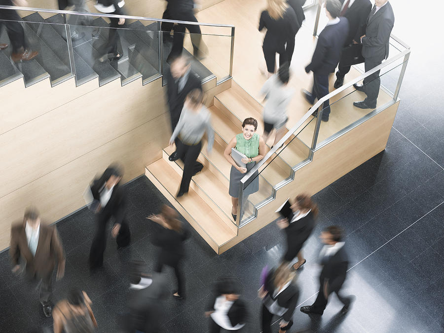 Businessman leaning on busy office staircase Photograph by Robert Daly