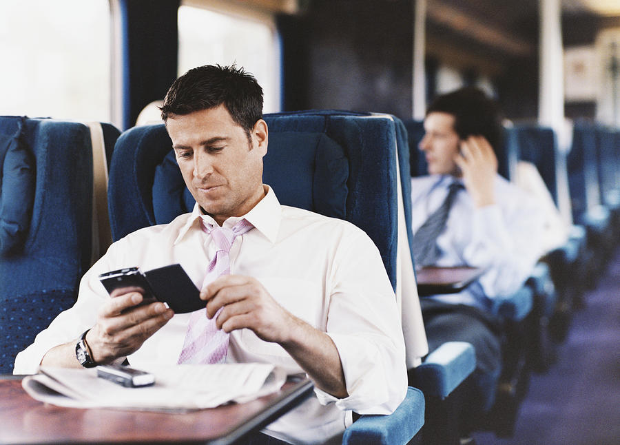 Businessman Looking at His PDA on a Passenger Train Photograph by Digital Vision.