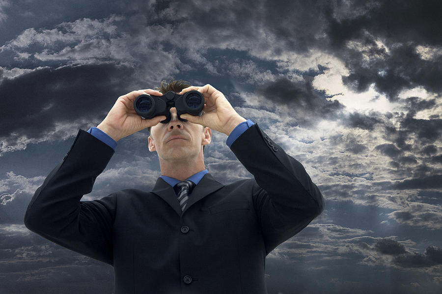 Businessman Looking Through Binoculars Against a Moody Sky Photograph by John Cumming