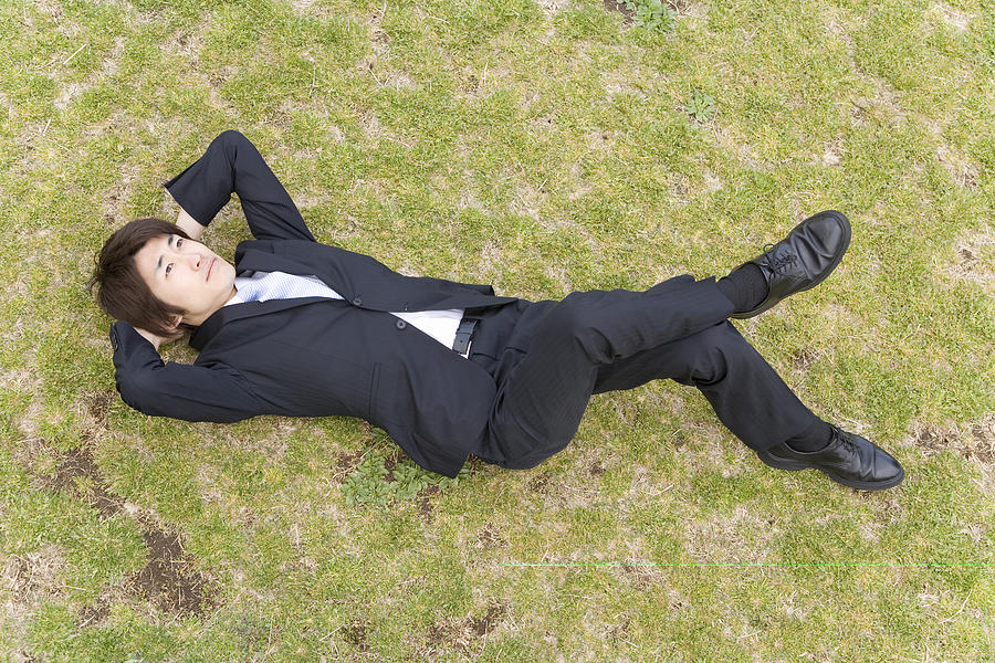 Businessman Lying On Grass Photograph by Daj