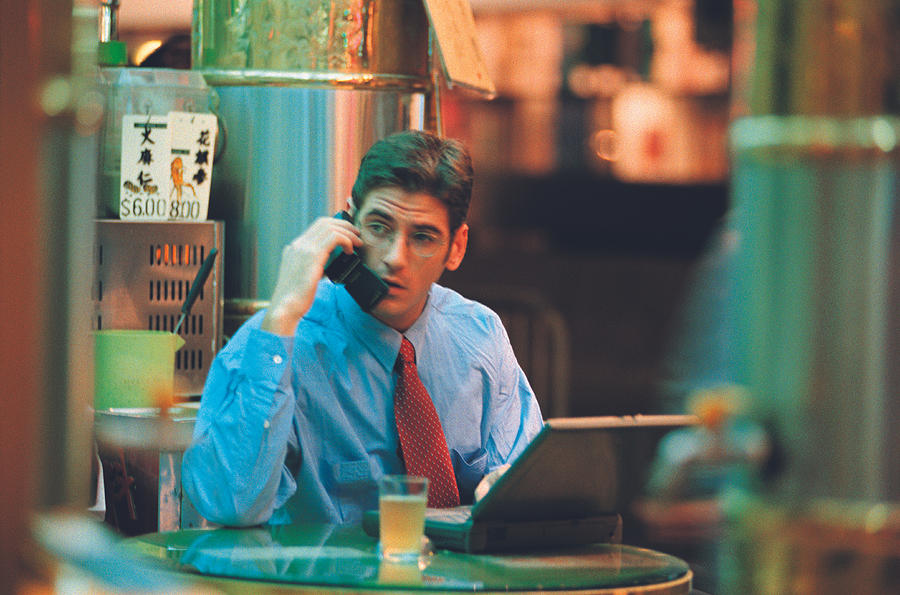 Businessman on phone with laptop Photograph by Photodisc