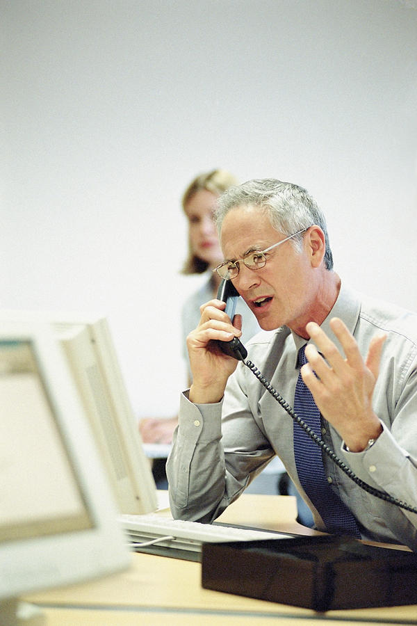 Businessman on telephone in office Photograph by Image Source