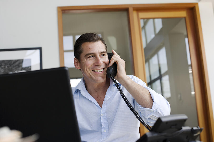 Businessman on telephone in office Photograph by Sam Edwards