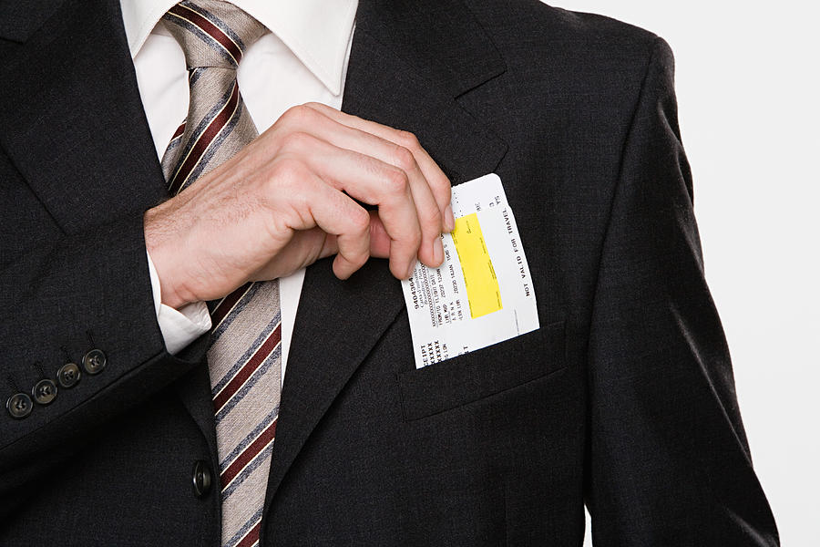 Businessman putting tickets in his pocket Photograph by Image Source