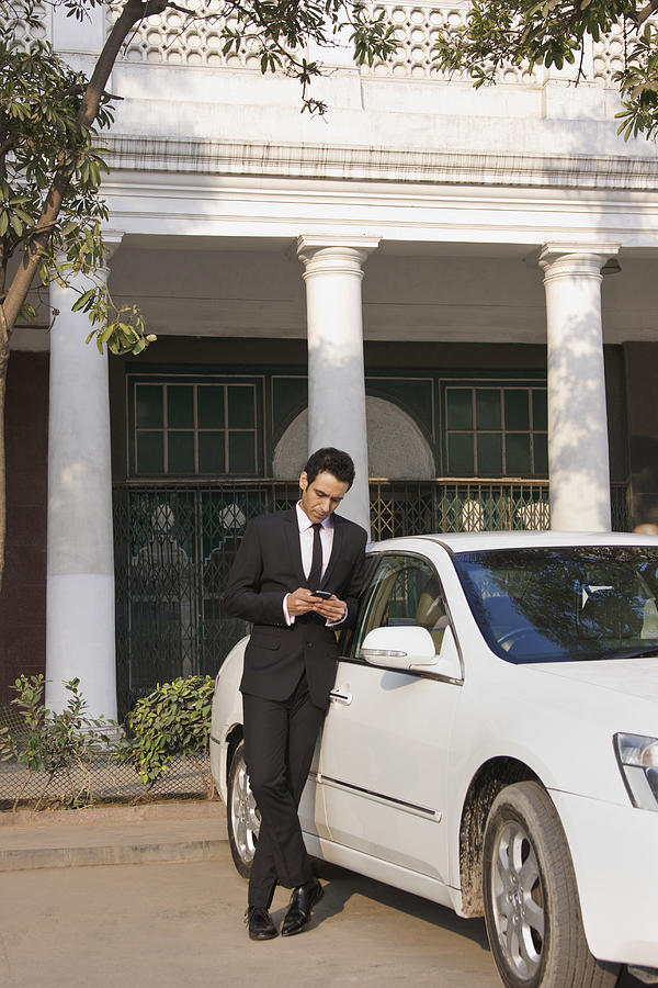 Businessman reading an sms on a mobile phone , INDIA , DELHI Photograph by Sudipta Halder