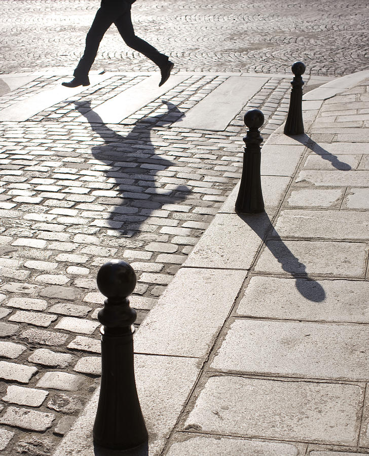 Businessman running along crosswalk on cobblestone street Photograph by Symphonie Ltd