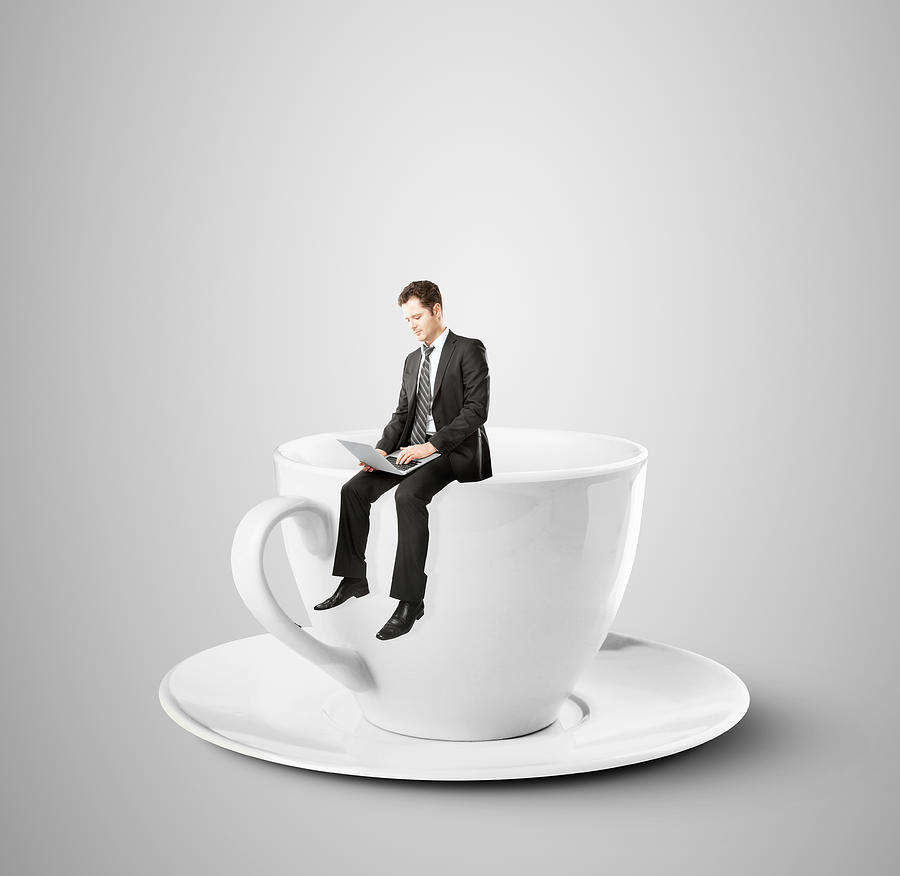 Businessman Sitting On Coffee Cup Photograph by Peshkova