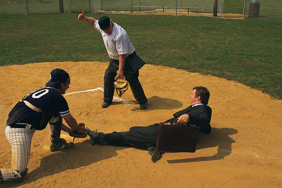 Businessman sliding into home plate is tagged out Photograph by Comstock
