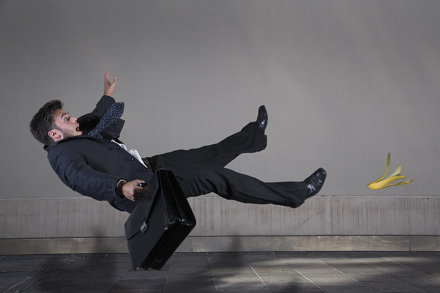 Businessman slipping on a banana peel Photograph by Buena Vista Images