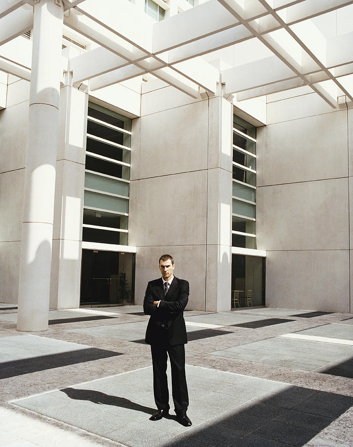 Businessman Standing by a Building With His Arms Crossed Photograph by Digital Vision.