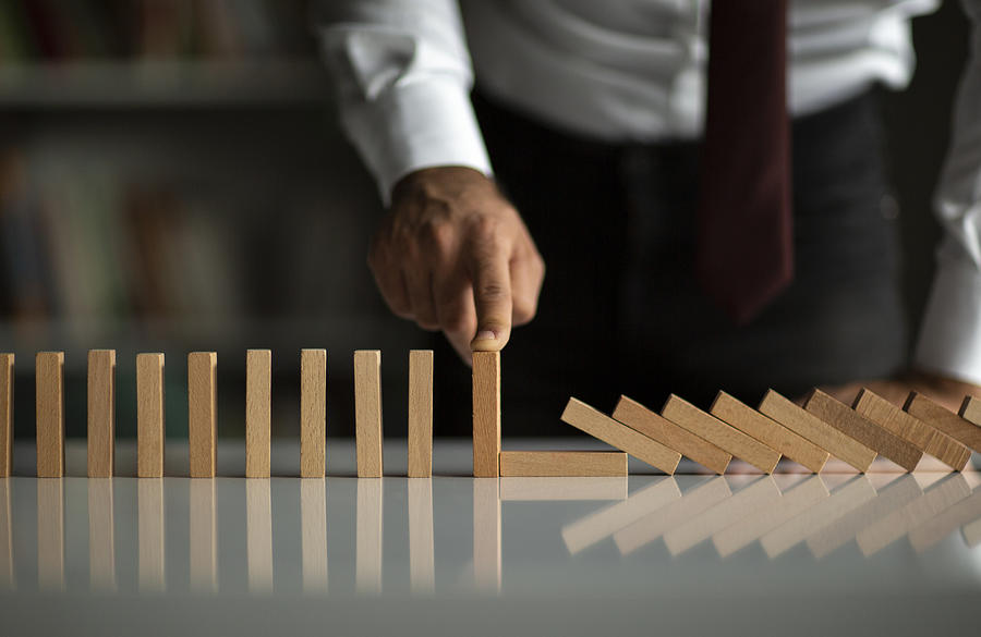 Businessman Stop Domino Effect. Risk Management and Insurance Concept Photograph by Ridvan_celik