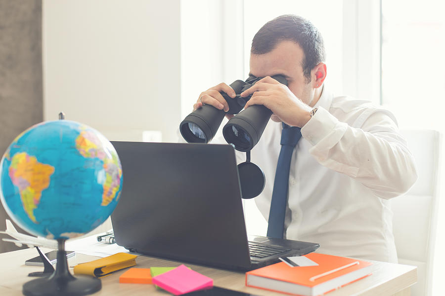 Businessman using binoculars for finding business profit Photograph by South_agency