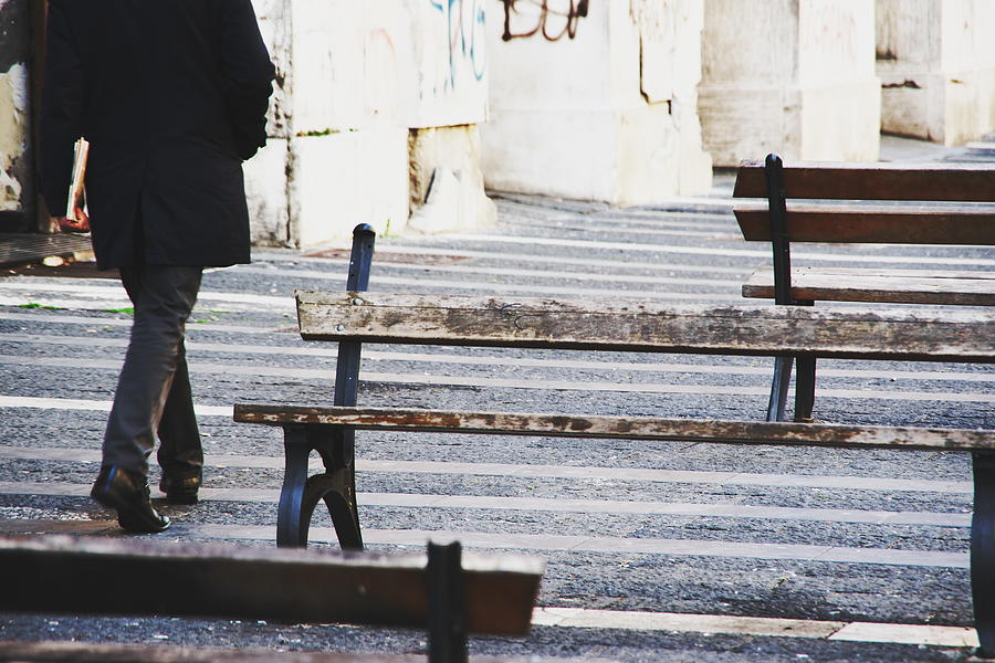 Businessman walking outdoors between benches Photograph by Maurizio Siani
