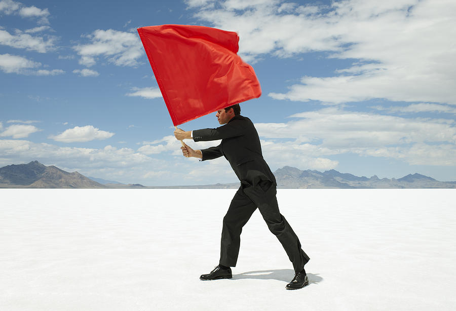 Businessman Waving Red Flag on Salt Flat Photograph by Andy Ryan