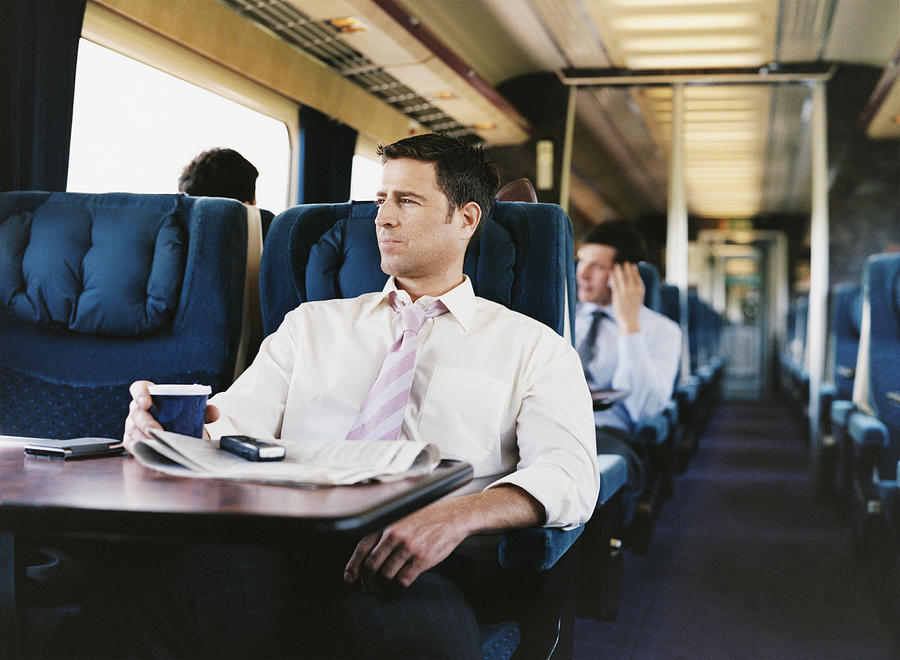 Businessman With a Cup of Coffee on a Passenger Train Photograph by Digital Vision.