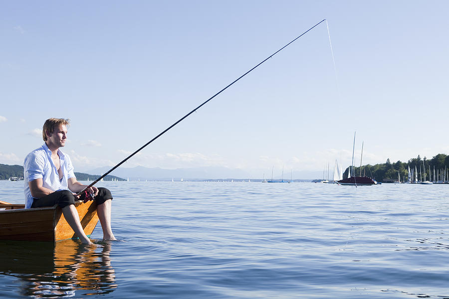 Businessman with fishing rod in rowboat Photograph by Severin Schweiger / Bernhard Haselbeck